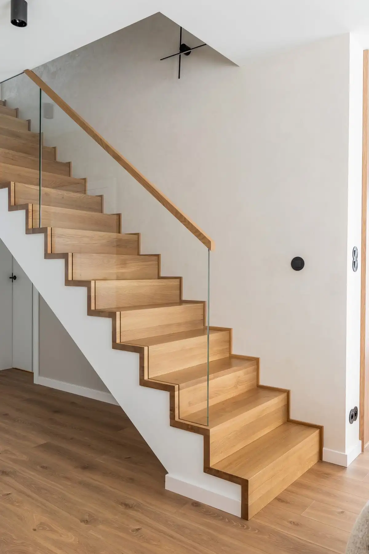 Schody dębowe ze szklaną balustradą i drewnianym pochwytem